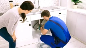 plumber repairing blocked kitchen sink – best plumbing company near