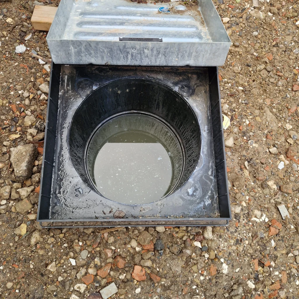 High-pressure water jetting equipment clearing a stubborn blockage in a residential drain pipe.
