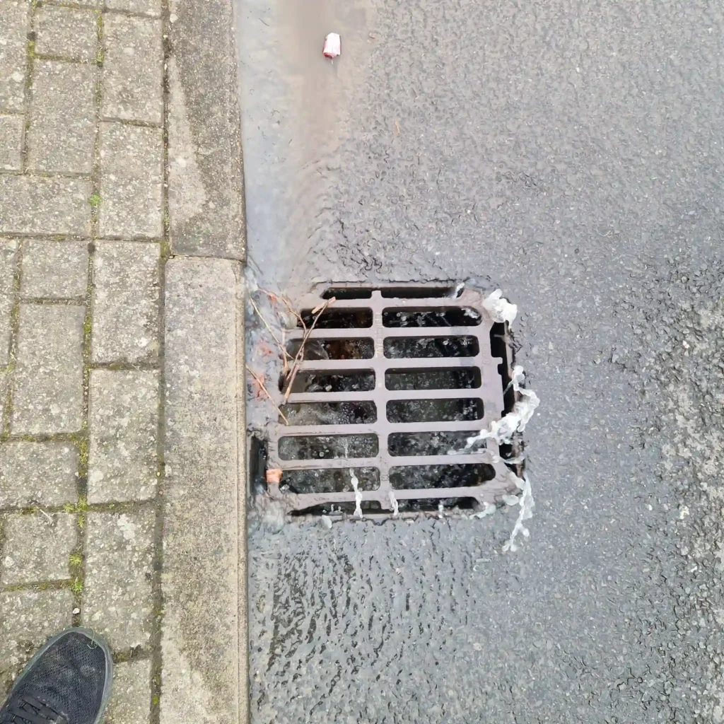 Drainage engineer using a high-pressure water jet to safely clear stubborn blockages and grease from a drain in Orpington.