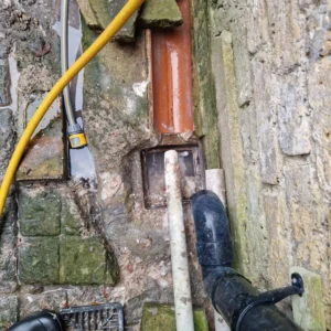 Kitchen sink overflowing with water due to grease and food blockage in the drain pipe.