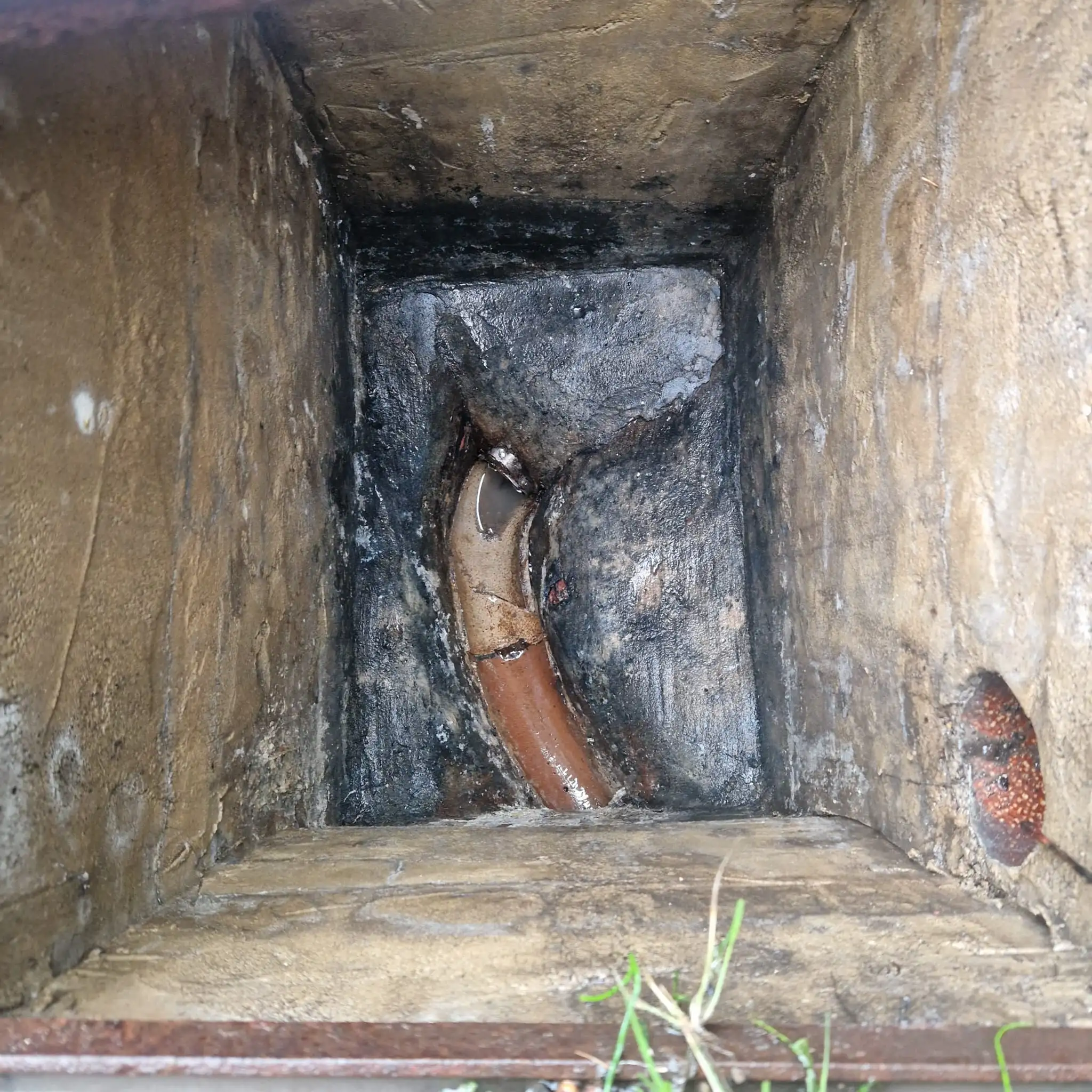High-pressure drain jetting hose inserted into an access point clearing a grease blockage in a South East England property