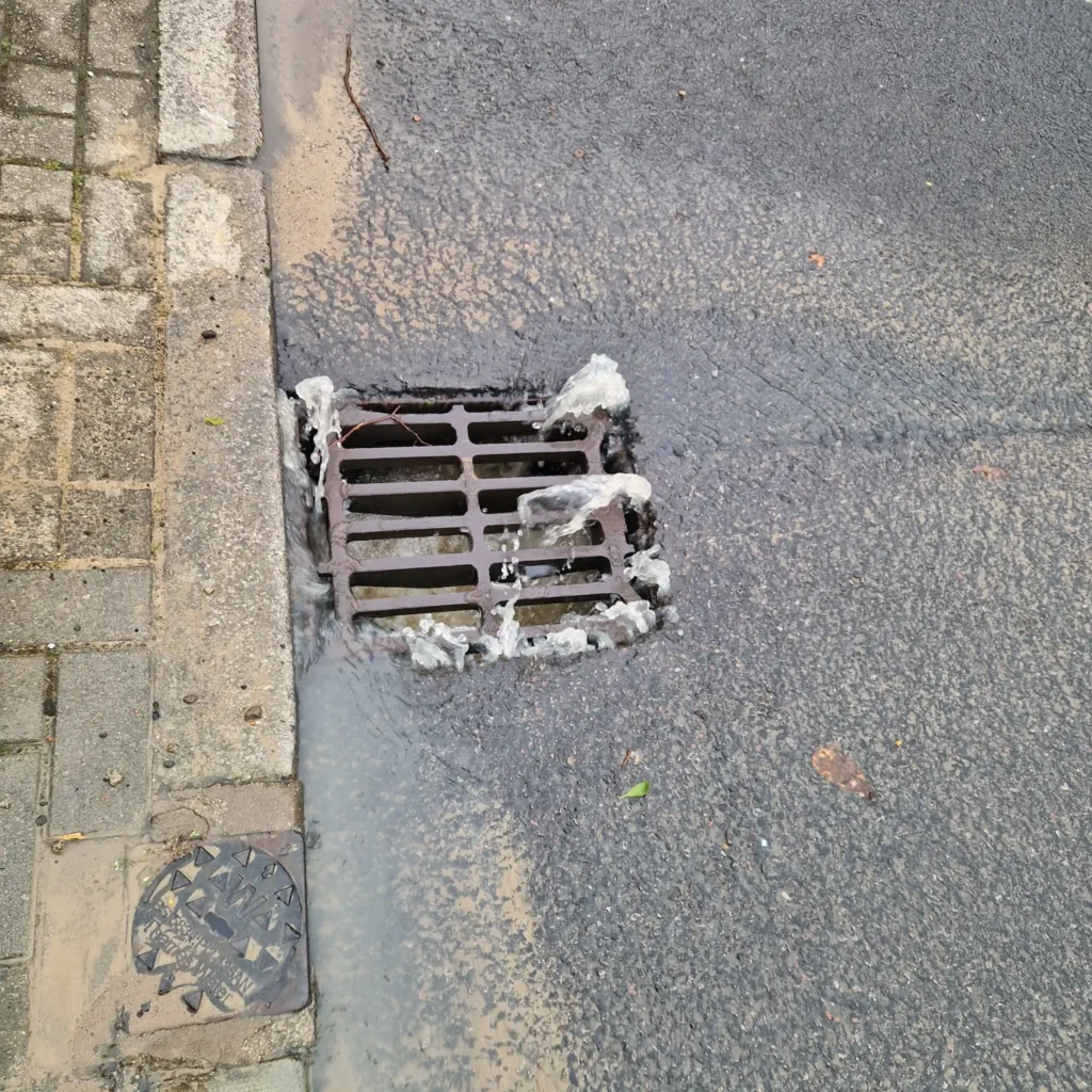 Professional drain unblocker using high-pressure water jetting equipment to clear a stubbornly blocked pipe.