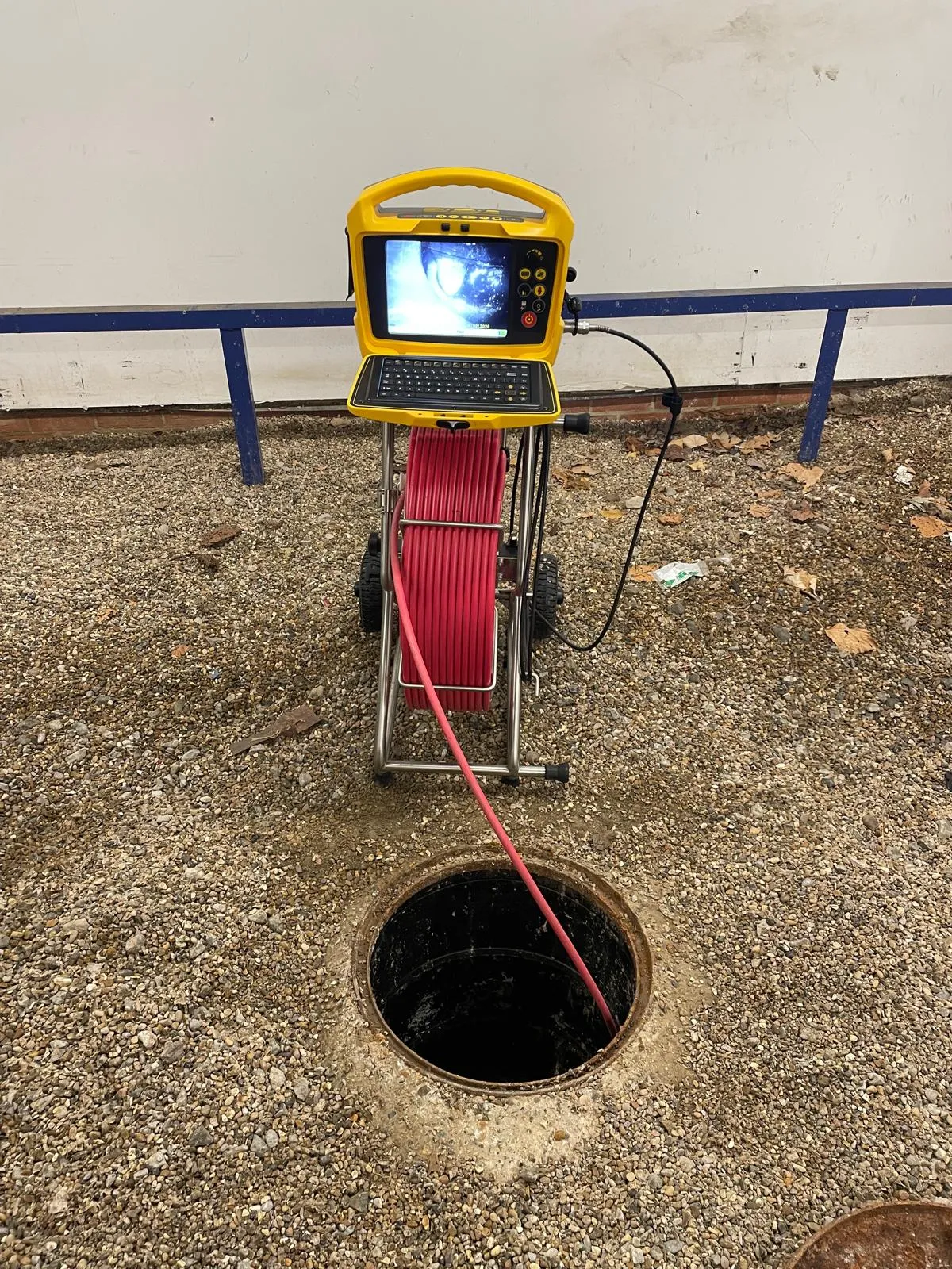 CCTV drain survey camera reel and monitor set up over an open manhole