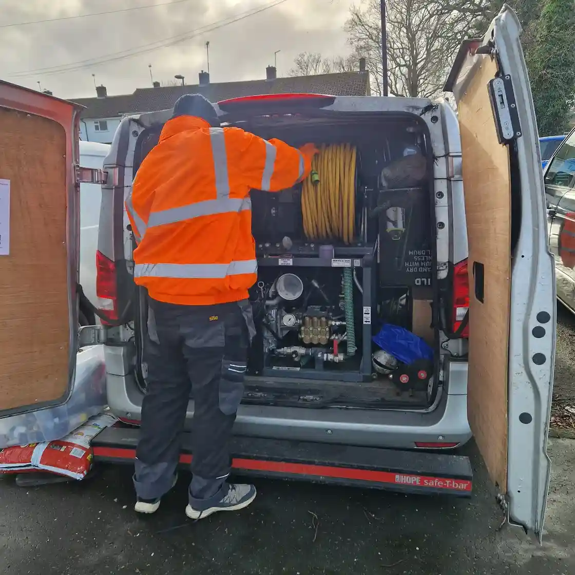 Drainage & Plumbing Ltd engineer preparing high-pressure drain jetter for emergency drain unblocking service