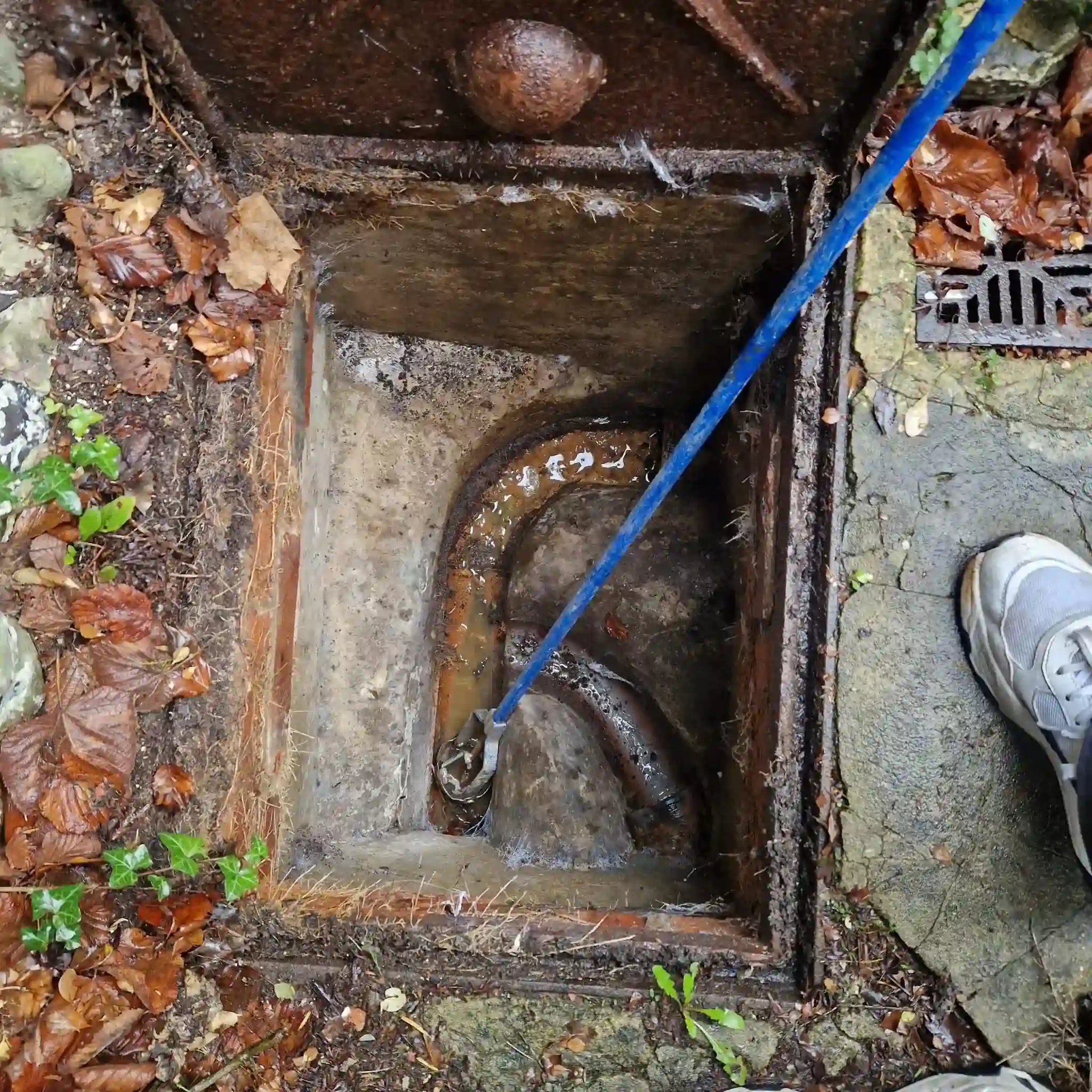 Drain engineer comparing drain jetting vs rodding equipment before clearing a blocked residential drain in South East England