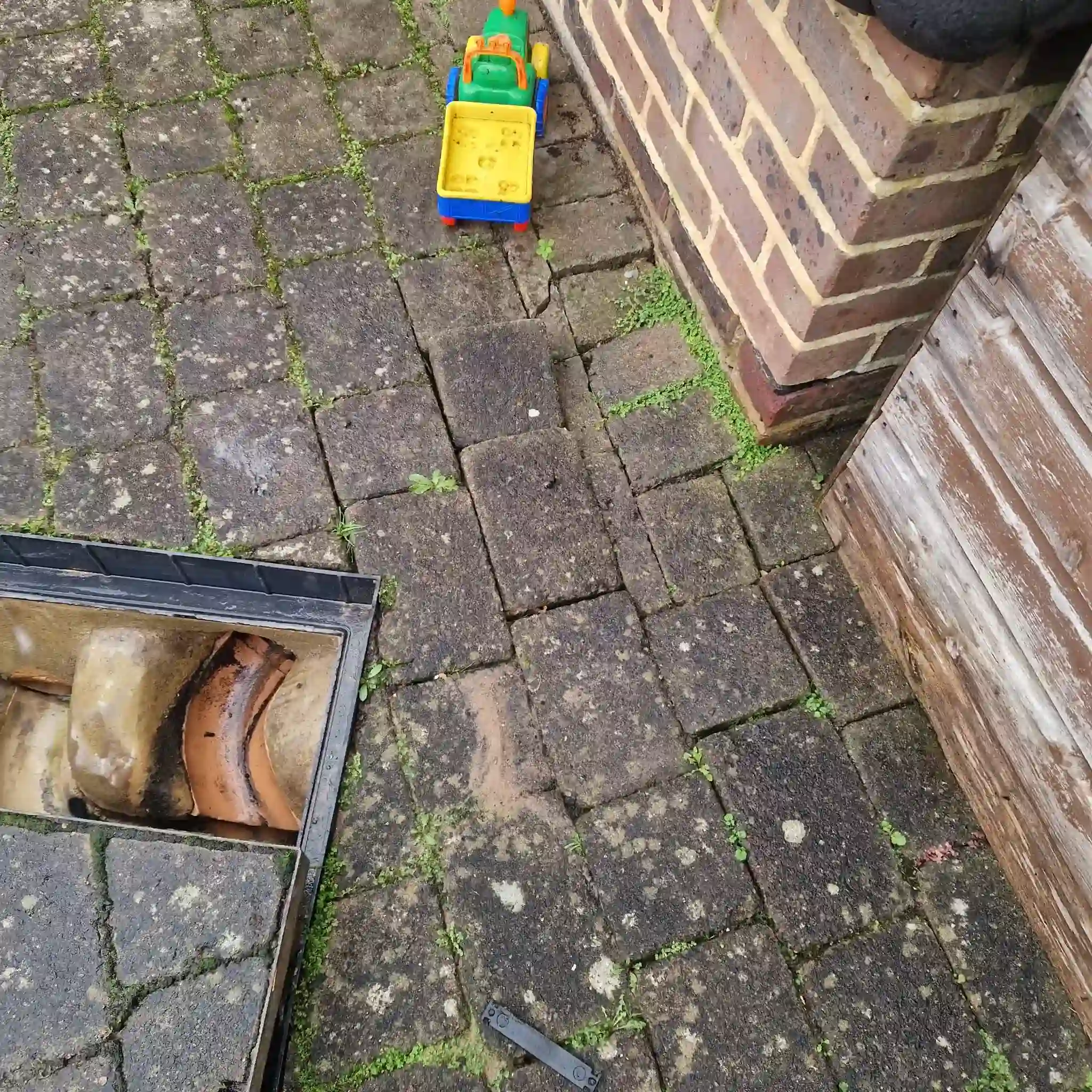 blocked drain London — engineer inspecting clay pipe in a London residential garden