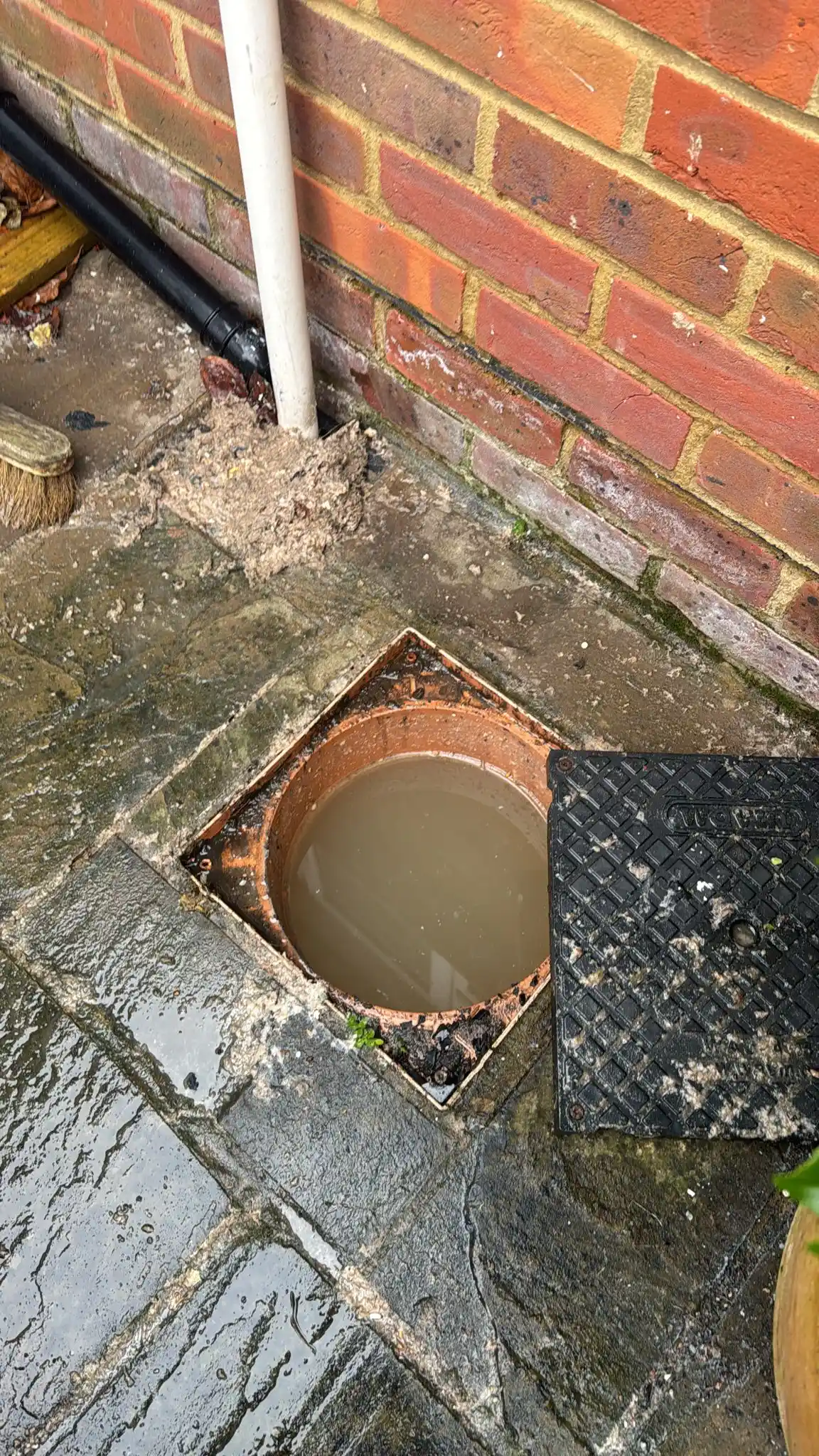 Drainage specialist Woldingham engineer preparing high-pressure jetting equipment outside a Surrey residential property