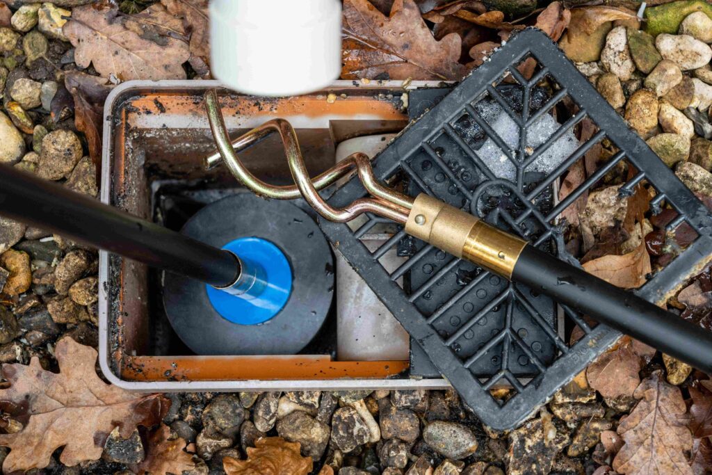 Emergency blocked drain unblocking engineer clearing a drain in London with high-pressure water jetting