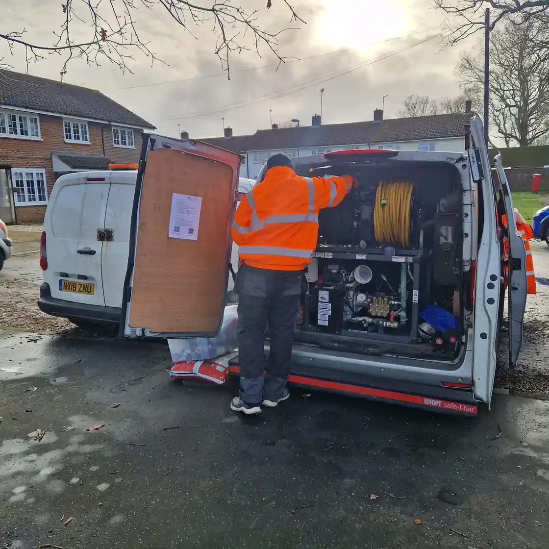 Drain unblocking engineer in Sutton inspecting drainage pipework