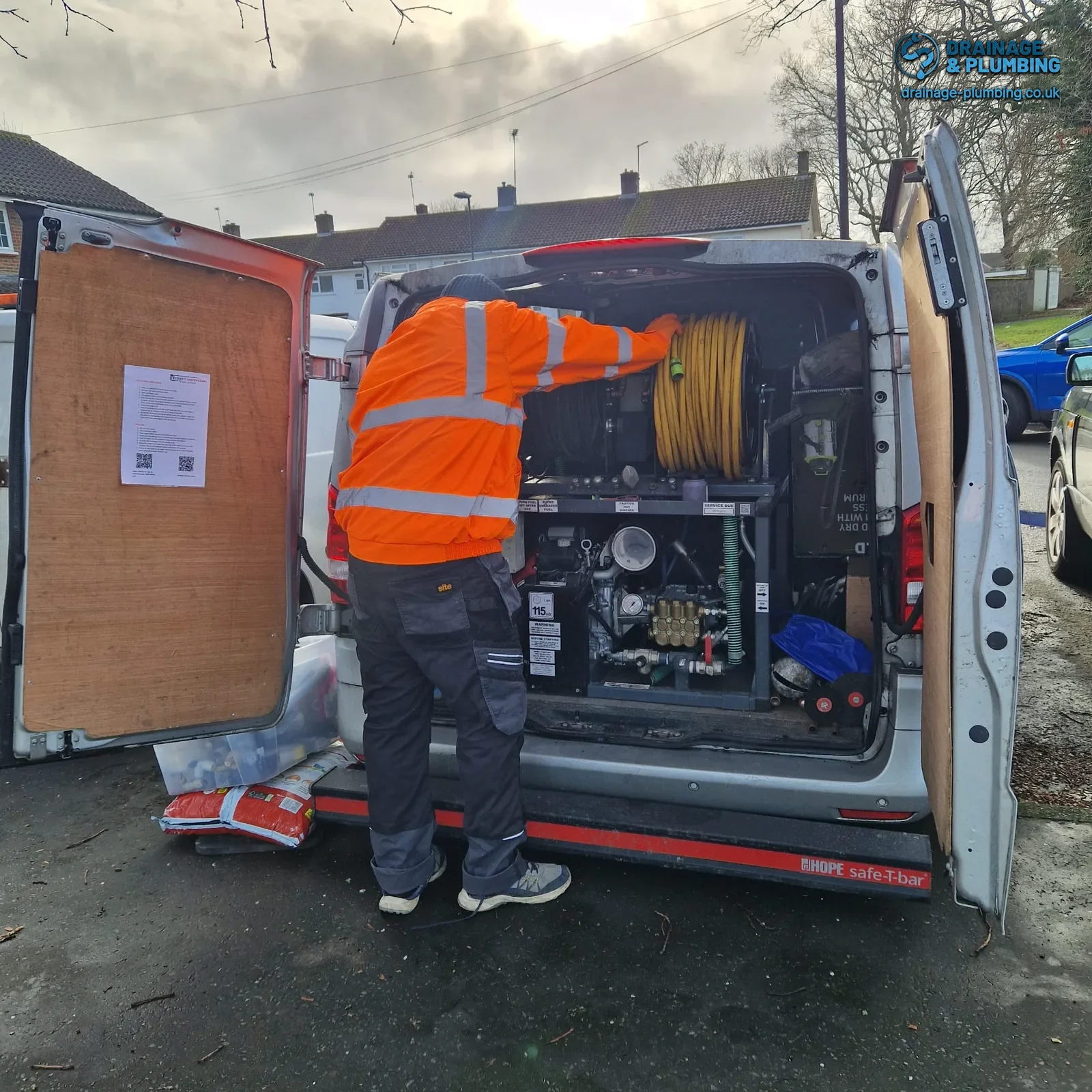 drainage engineer preparing high-pressure jetting hose to clear a blocked outside drain