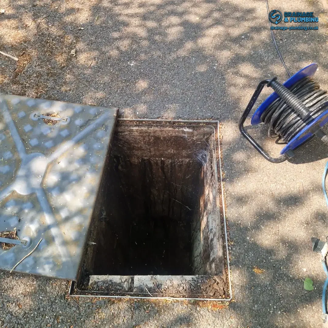 blocked drain specialist using a CCTV drain camera to locate a cracked joint after summer heat pipe damage