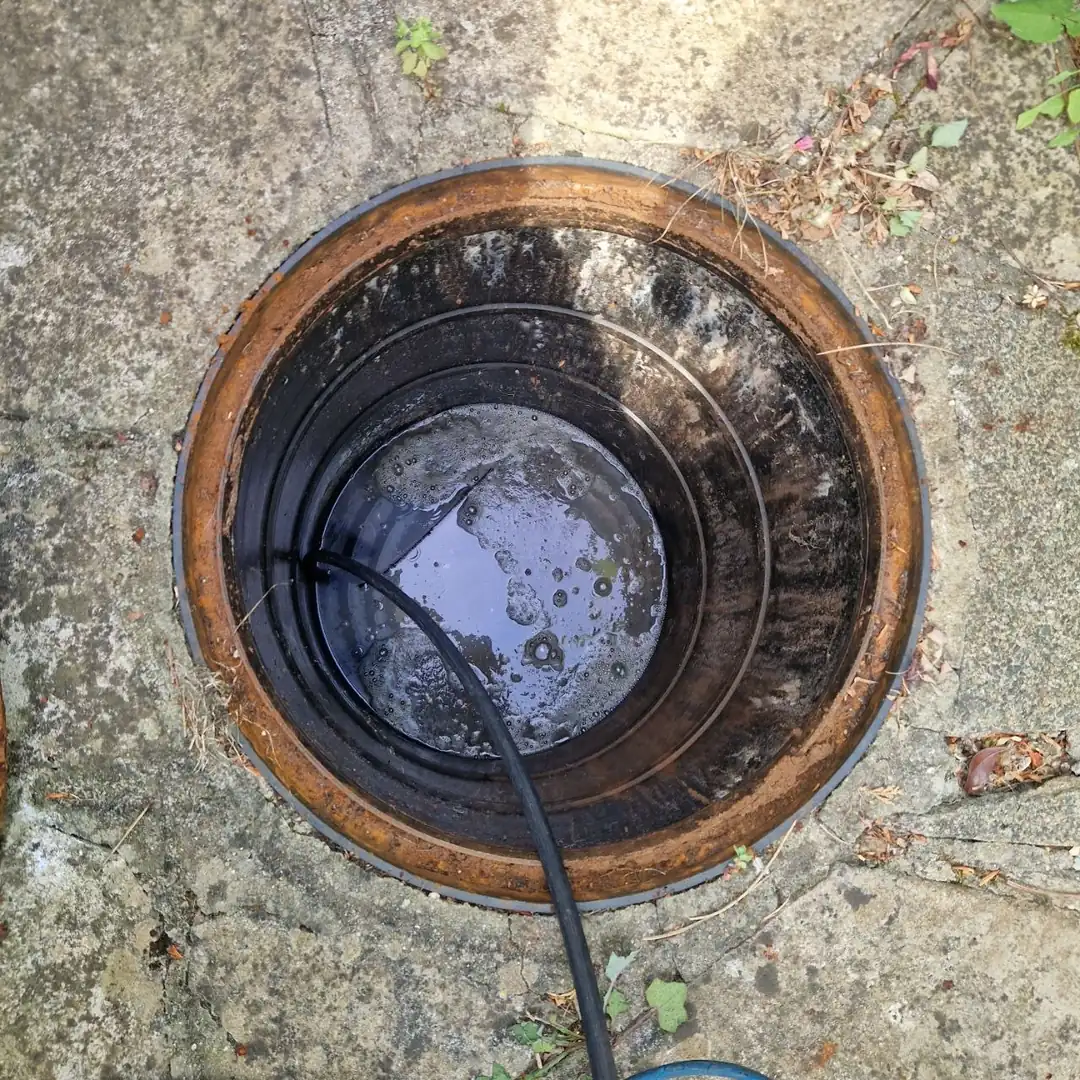 cracked clay drain pipe joint showing early-stage collapse before visible garden subsidence appears