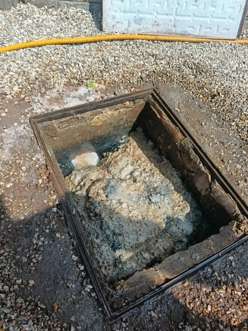technician using mechanical drain snake to clear a blocked toilet drain run