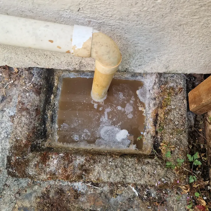 The same gully running clear again, with water going straight down from the downpipe