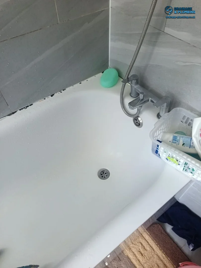 Shop-bought one-shot drain cleaner beside a kitchen sink, illustrating a limited short-term DIY fix