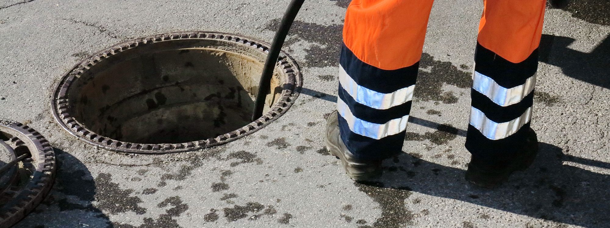 Sewage Spills & Sewer Flooding Across South London & Surrey: 2022-2025 1 A drainage engineer working at an open manhole cover during sewer maintenance